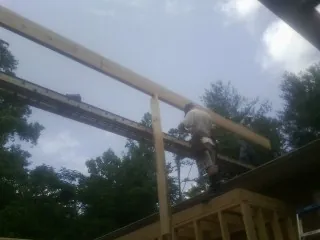 Carpenter setting a ridge beam over a new addition frame — Ice Dam Removal by Roofing Brothers in Cedar City