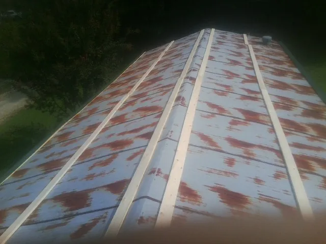 Rusted metal roof panels with new wood purlins before replacement — Storm Damage Roof Repair in Cedar City by Roofing Brothers